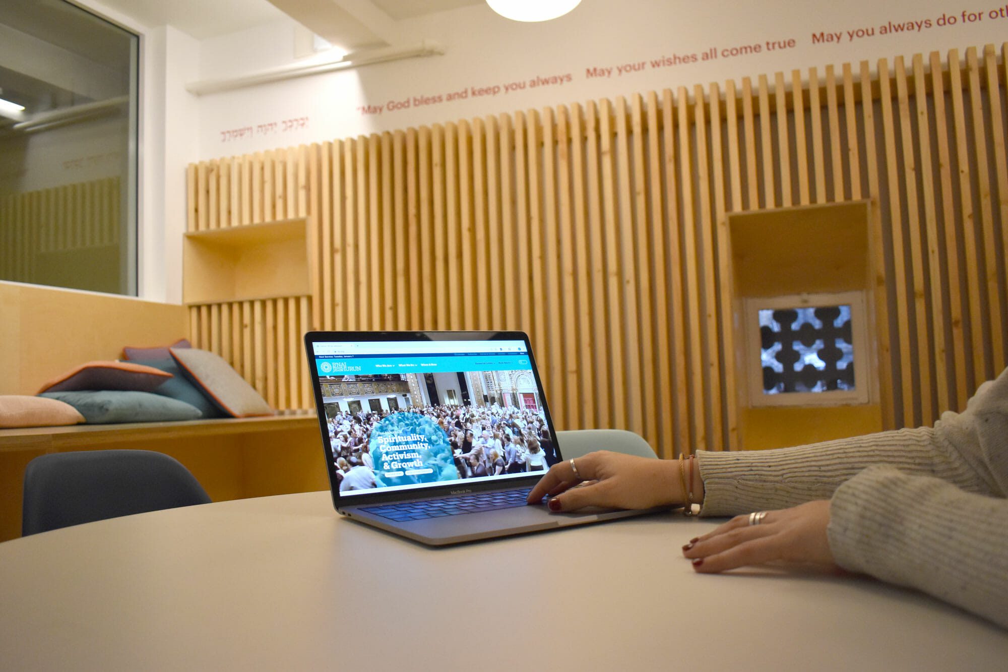 hands on laptop, looking at b'nai jeshurun site