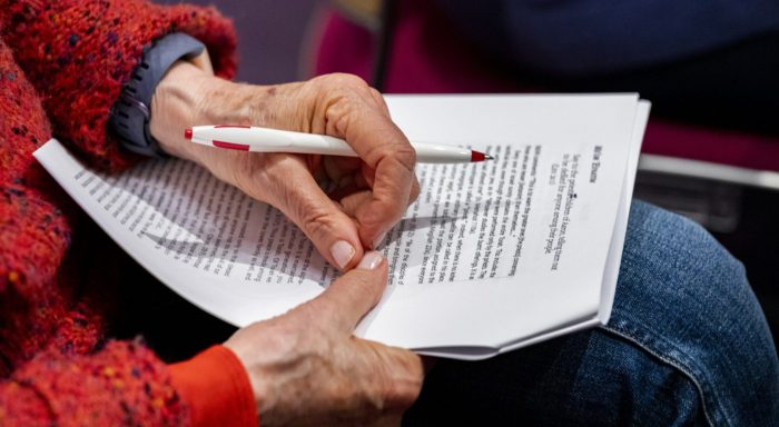 woman holding paper with pen in hand