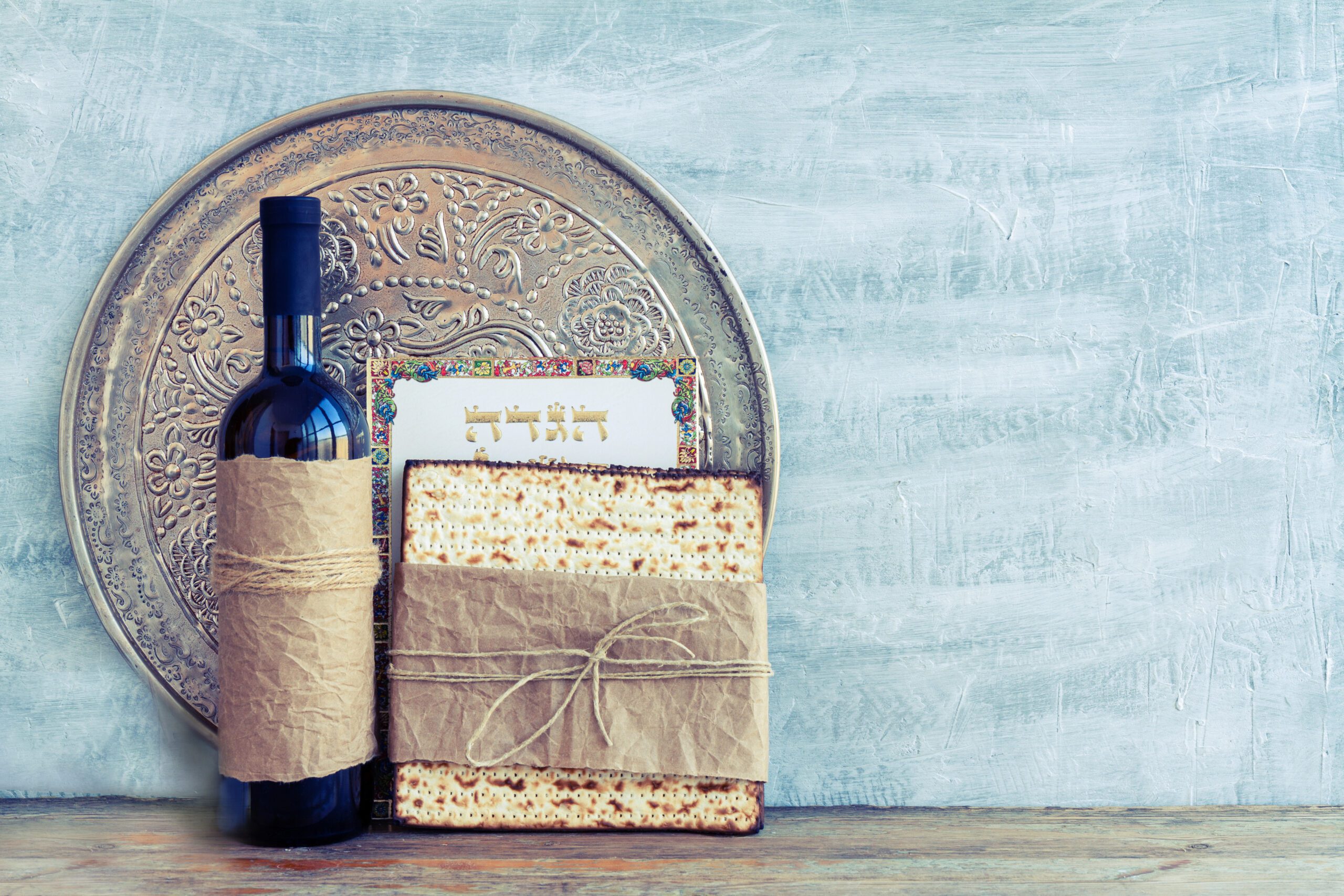 Seder plate, bottle of wine, matzah, and haggadah