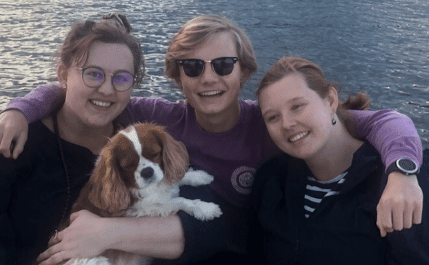 family with a dog on a lake